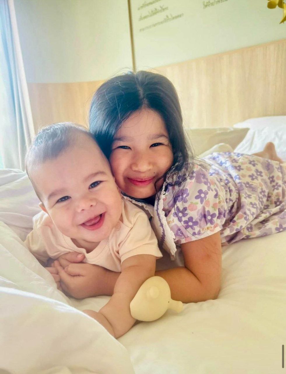 Kids lying on the bed smiling