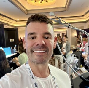 Dr bart scanlon smiling in front of busy conference hallway