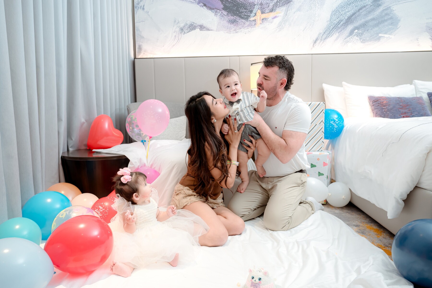 Bart and Airada holding baby Johnny with balloons in background