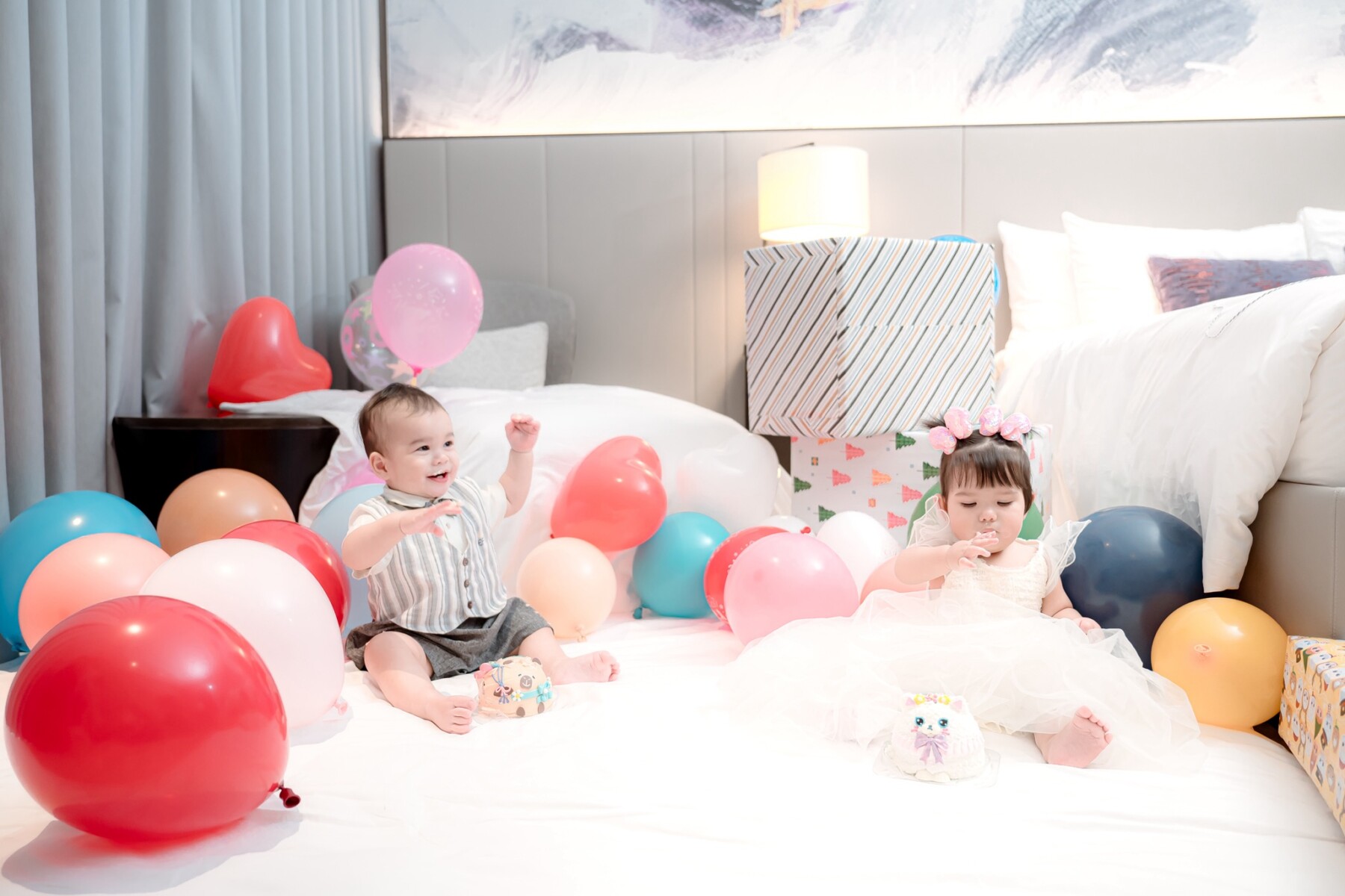 Smiling twins enjoying balloons at birthday party