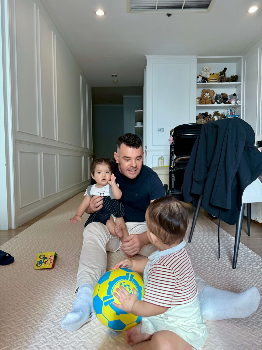 Bart Scanlon sitting on floor playing with twins