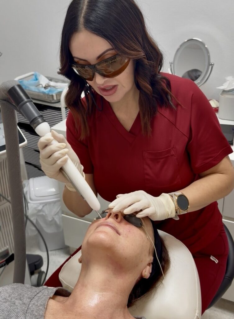 Sharon Leayr performing laser treatment on patient's face
